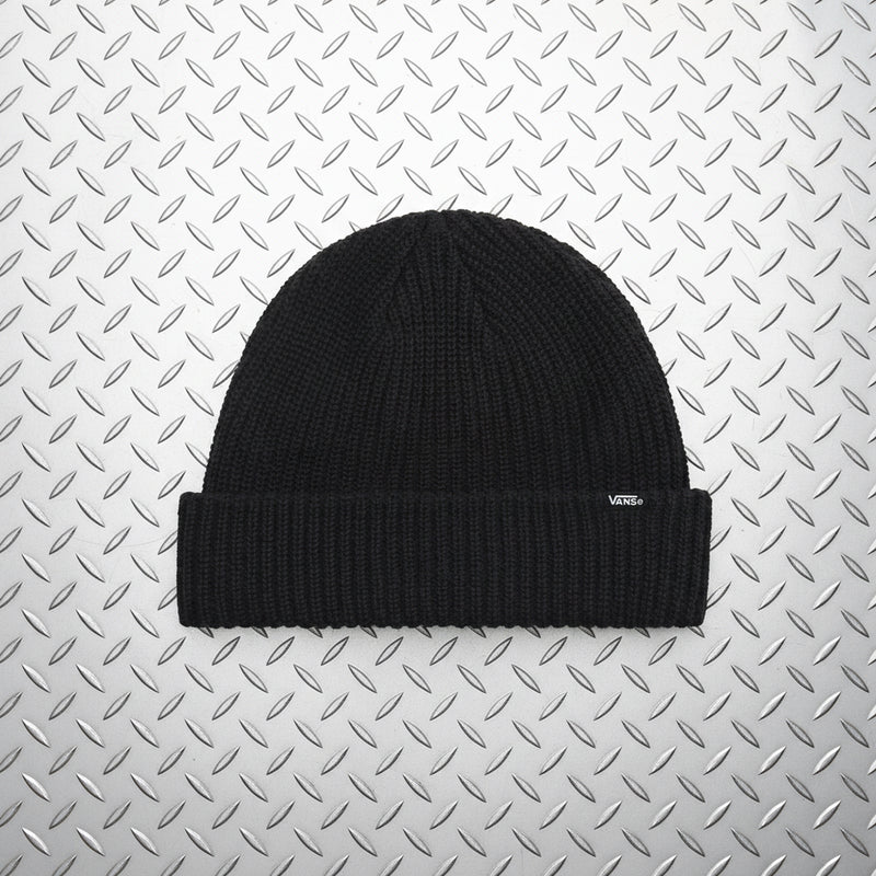 A black ribbed knit beanie hat with a folded cuff, shown against a solid light beige background. A small white Vans logo is visible on the right side of the cuff.